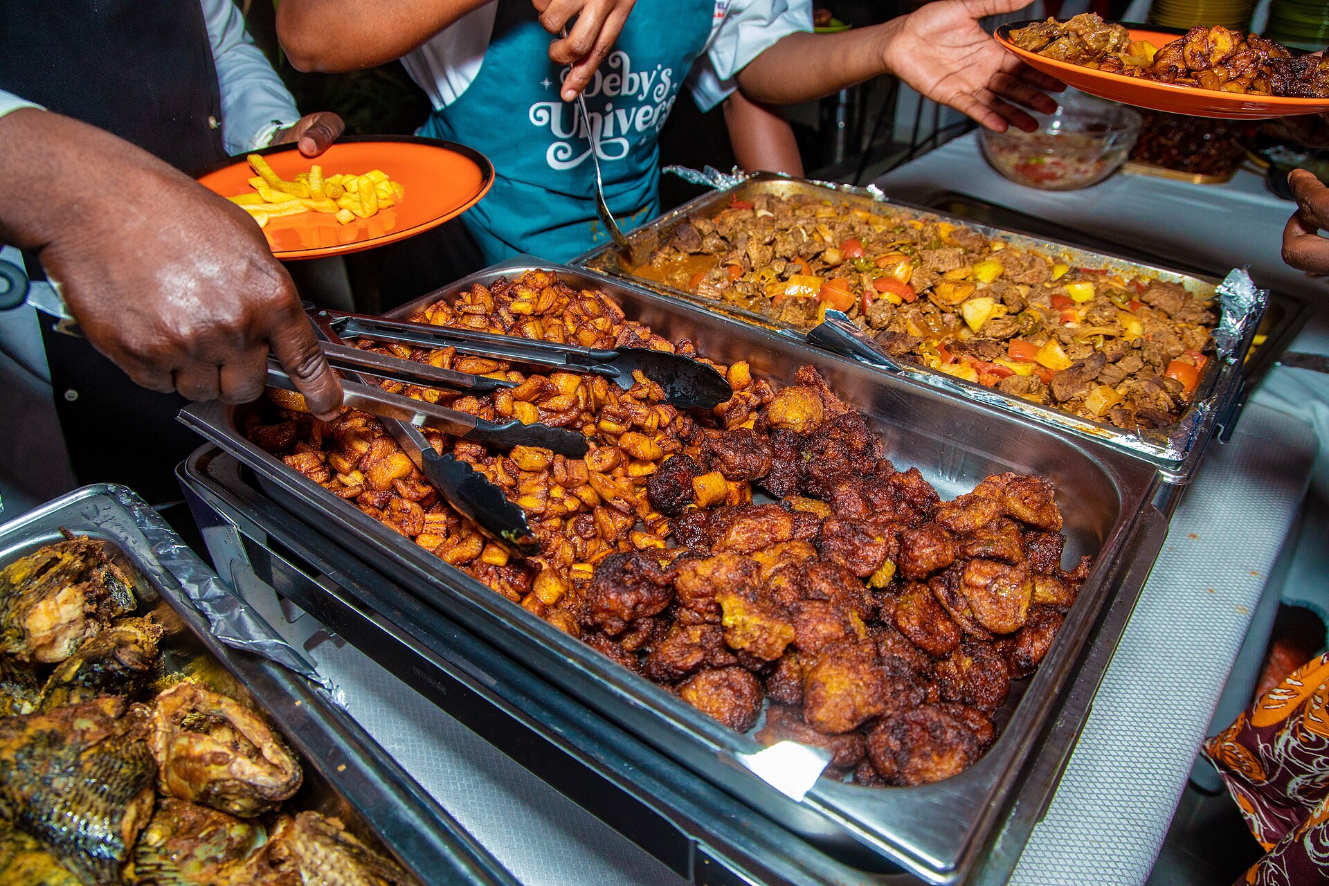 Bacs d’alloco, bananes plantain frites, et de claclo servis par une vendeuse