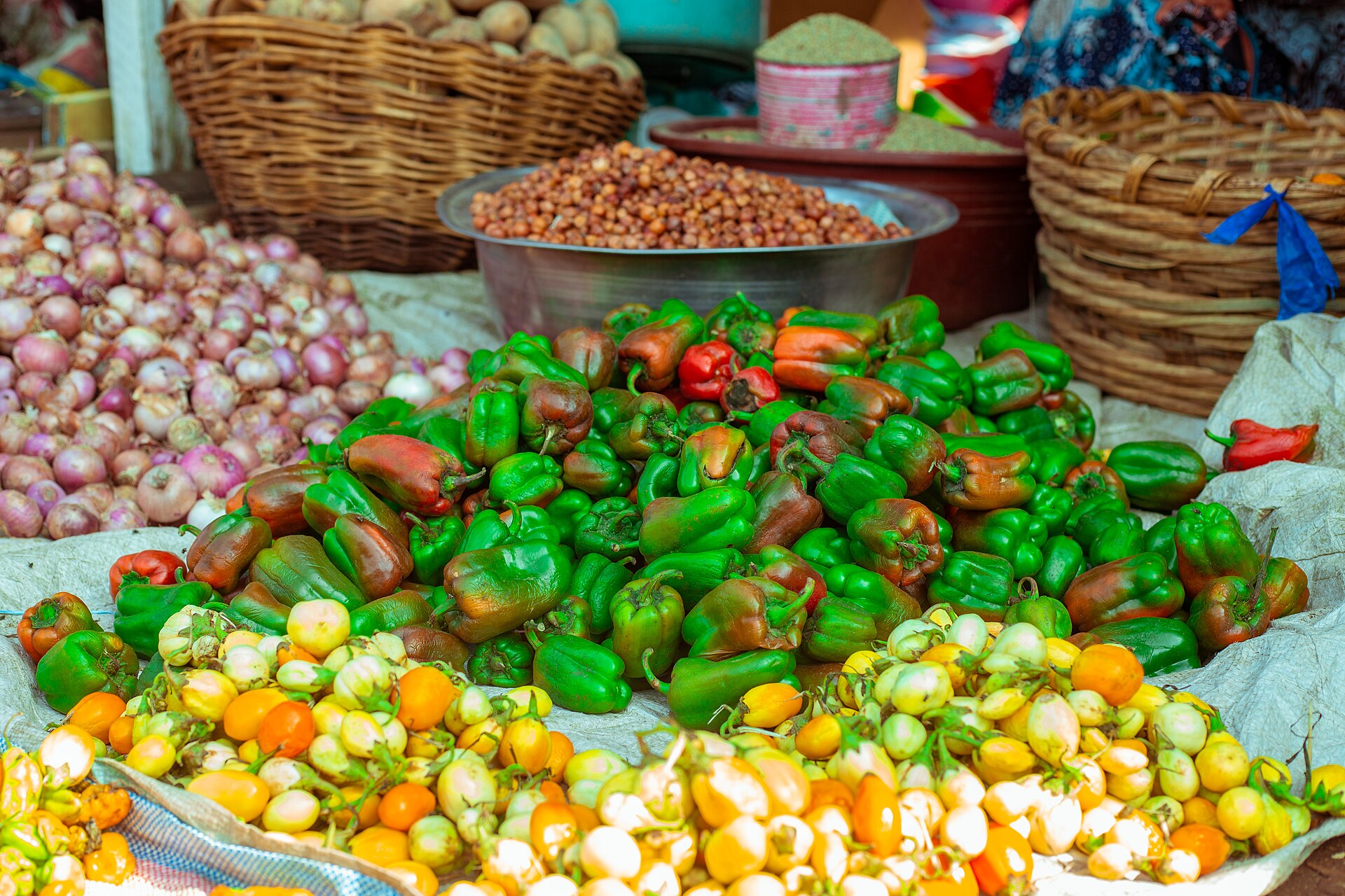 Étal de petites aubergines et de poivrons colorés sur un marché de Bouaké