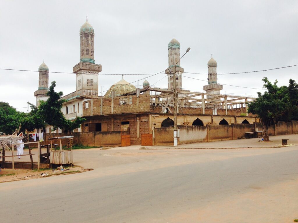 Grande mosquée de Bondoukou avec ses minarets blancs, au bord d’une rue