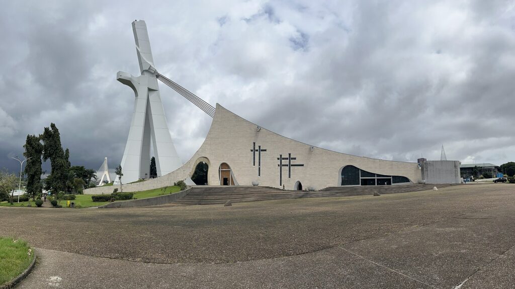 Cathédrale Saint-Paul du Plateau à Abidjan, grande croix de béton blanche inclinée tenue par des haubans au-dessus de la nef