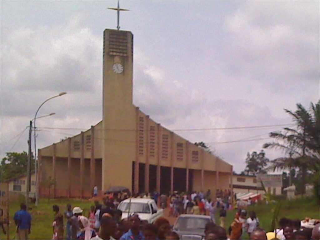 Cathédrale Sainte-Anne de Gagnoa avec son clocher carré, et une foule de fidèles devant l’entrée