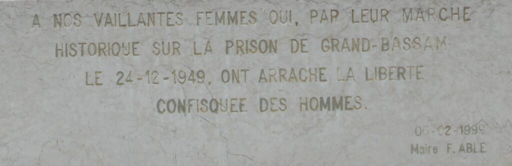 Inscription gravée sur le socle du monument rendant hommage aux femmes qui ont marché sur la prison de Grand-Bassam en décembre 1949