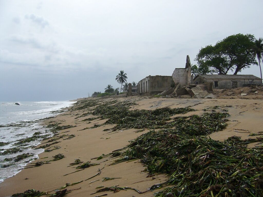 Bâtiments en ruine au bord d’une plage attaquée par la mer à Grand-Lahou