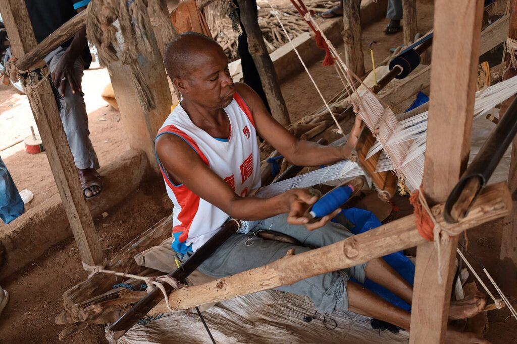 Tisserand travaillant sur un métier à tisser traditionnel au marché artisanal de Waraniéné, près de Korhogo