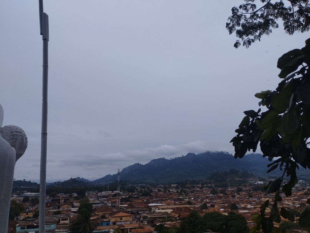 Toits de tôle de la ville de Man et montagnes sous un ciel nuageux
