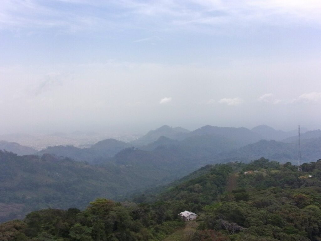 Succession de collines et de montagnes boisées dans la brume, vues depuis les hauteurs en direction de Man