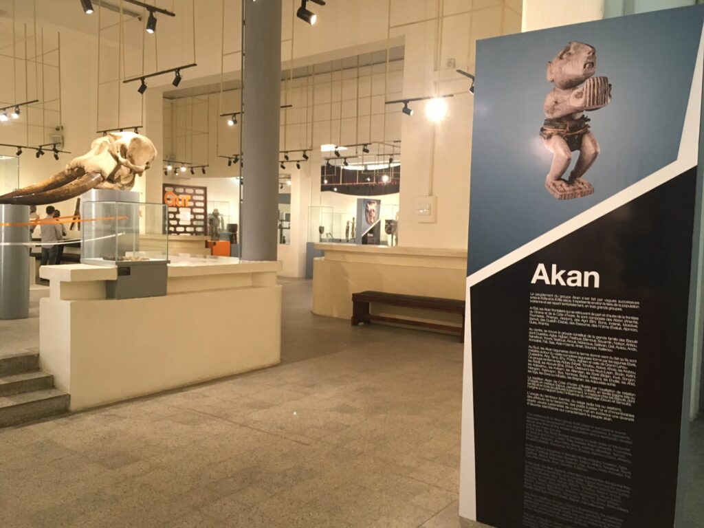 Salle d’exposition du Musée des civilisations de Côte d’Ivoire, avec vitrines et panneau consacré aux arts akan