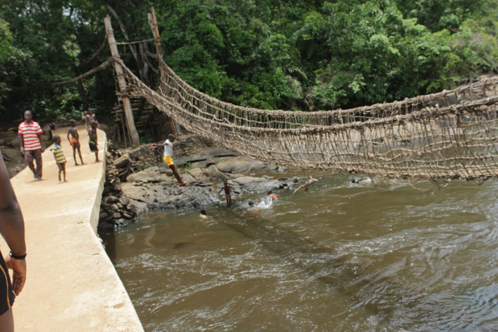 Pont de lianes de Lieupleu tendu au-dessus du Cavally, près de Danané, à côté d’un pont en béton où passent des visiteurs