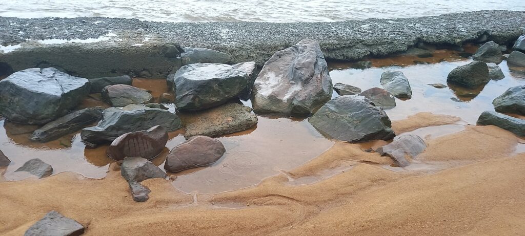 Rochers noirs sur une plage de sable à Tabou, près de la frontière libérienne