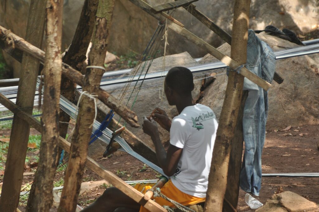 Artisan tisserand travaillant sur un métier à tisser traditionnel en bois à Man